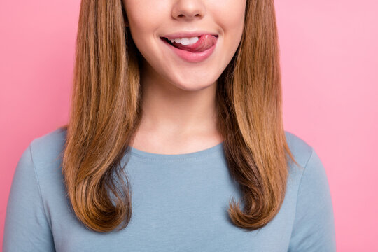 Cropped view portrait of attractive cheerful hungry funny girl licking lip isolated over pink pastel color background