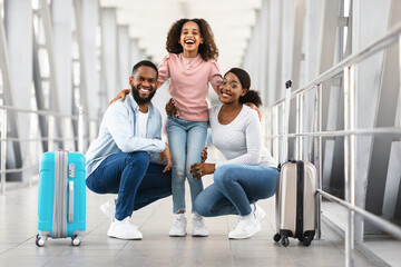 Wall Mural - Black family traveling, posing together in modern airport