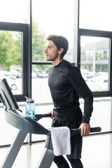 Wall Mural - Sportsman running on treadmill near sports bottle and towel in gym