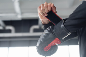 Wall Mural - Cropped view of man wearing boxing glove in sports center