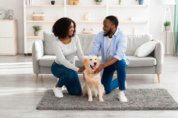 Wall Mural - Black spouses spending time at home patting labrador