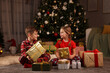 © New Africa - Cute little children with gift boxes near Christmas tree at home