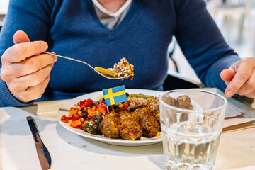  woman eating Swedish traditional meatballs with fried potatoes and cranberry sauce. Swedish food concept.