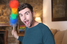 Cute Man Holding Feather Duster With The Rainbow Colors 