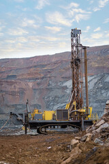 Wall Mural - Large drill rig in an ore quarry. Preparation of boreholes for laying explosives in the quarry. Open-pit mining technologies.