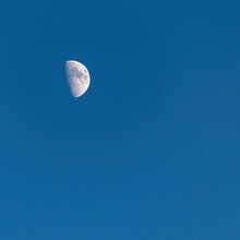 Half Bright Moon Visible Afternoon Time On The Blue Sky