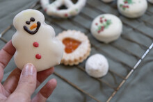 Close-up Of Hand Holding Snowman Cookie With Copy Space.