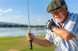 Asian senior man caught injury shoulder while golfing at country club on summer vacation. Elderly male golfer shoulder pain while outdoor sport workout. Senior people medical and healthy care concept