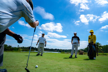 Group of Asian people businessman and senior CEO golfing near the hole on golf fairway together at country club. Healthy elderly man golfer enjoy outdoor golf sport and leisure activity with friends.