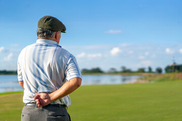 Asian senior man caught his injury back pain while golfing at country club on summer vacation. Elderly male golfer back ache while outdoor sport workout. Senior people medical and healthy care concept