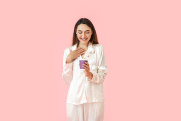 Sticker - Beautiful woman in pajamas and with cup of coffee on color background