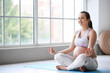 © Pixel-Shot - Sportive pregnant woman meditating on yoga mat in gym