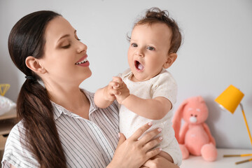 Canvas Print - Young mother holding her little baby in bedroom