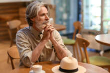 Handsome Mature Man At Table In Cafe