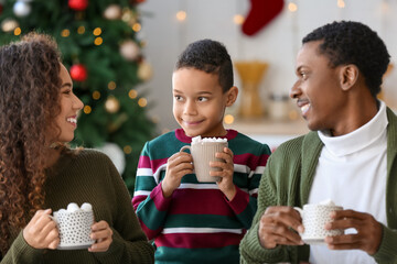 Poster - Happy African-American family drinking tasty hot chocolate at home on Christmas eve