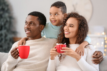 Poster - Happy African-American family drinking tasty hot chocolate at home on Christmas eve