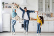 © Prostock-studio - Cheerful arab family of three dancing in kitchen, having fun at home