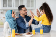 © Prostock-studio - Joyful arabic family of three having fun while eating breakfast in kitchen