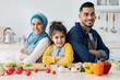 © Prostock-studio - Happy Middle-Eastern Mother, Father And Little Daughter Posing In Kitchen While Cooking