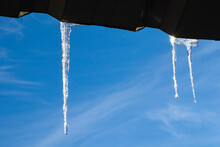 Icicles On The Roof, Blue Sky And Iced Water