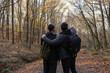 Two boys are walking on the forest. One of them showing far away to others. Friendship and brotherhood concept photo. Hiking, sport and active lifestyle concept photo. Fresh air at outdoor.