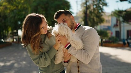 Poster - young couple kissing and hugging dog at park