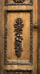 Wooden carved door detail. Carved decoration in the form of leaves and fruits. Carved frame