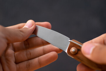 hands holding a sharp folding dagger