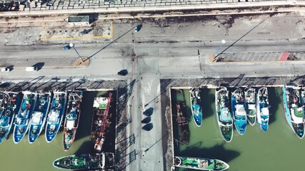 Wall Mural - Fishing boats in a small port, aerial overhead view from drone