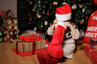 © M-image - young girl searching stocking sock beside Christmas tree at home