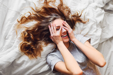 Pretty blonde woman have fine on her bedroom.  Young   lady enjoying her morning and wake up.