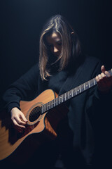 Wall Mural - A young woman with an acoustic guitar in the dark under a ray of light.