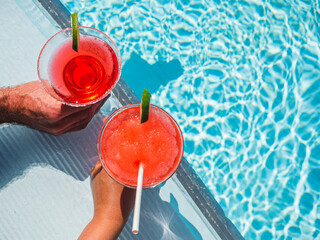 Wall Mural - Beautiful glass with a refresh cocktail on the background of the swim pool. Top view, close-up. Vacation and travel concept. Moments of celebration