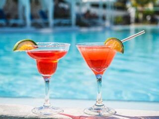 Wall Mural - Beautiful glass with a refresh cocktail on the background of the swim pool. Top view, close-up. Vacation and travel concept. Moments of celebration