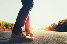 Concept Of Walking Towards The Goal. New Year 2022. Leg Wearing Shoe On Road With Sunshine