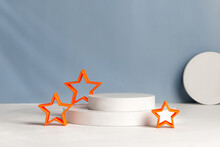 Podiums With Orange Stars For Presentation And Cosmetic. Natural Beauty Pedestal In Sunlight. Shadow On Blue Wall. Photography