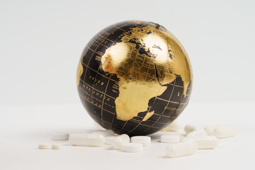 global diseases and treatment. there are medicines near the black and golden globe - covered by a pa