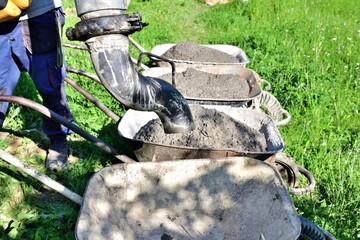 The concrete remains from the pump machine are poured into the wheelbarrow