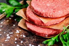 Raw Burger On A Cutting Board With Parsley And Salt. Macro Background. High Quality Photo