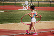 © Trepalio - Niña con el aro hula hula como parte de su entrenamiento de atletismo en las instalaciones deportivas.