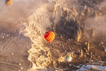 Hot air balloons flying over spectacular Cappadocia. Beautiful view of hot air balloons floating in sunrise blue sky over the mountain landscape of fairy chimneys