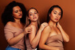 © iordani - young pretty asian, caucasian, african woman posing cheerful together on brown background, lifestyle diverse nationality people concept