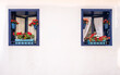 © Javier - two blue windows decorated with flower pots with red flowers on a house with white walls, typical mediterranean village, copy space