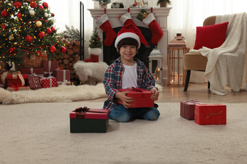 Wall Mural - Happy child with Christmas gifts on floor at home