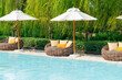 outdoor patio chair with pillow and umbrella around swimming pool