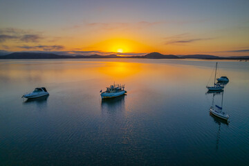 Naklejka na meble Sunrise waterscape with boats, soft clouds and reflections