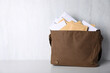 © New Africa - Postman's bag full of letters and newspapers on white wooden background. Space for text