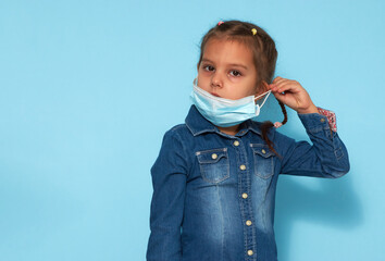 Wall Mural - Little girl wearing face mask over blue background