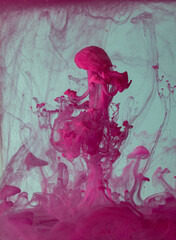 Wall Mural - Explosion of colored fluid, ink, dye and neoned liquid on blue-gray studio background with copyspace