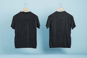 Poster - Empty black t-shirts on blue wall background, Product design and presentation concept. Mock up logo. 3D Rendering.
